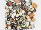 un sac rempli de capsules de bière posé sur une surface blanche