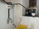 a yellow bucket sitting next to a wall with electrical wires on it