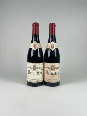two bottles of red wine sitting next to each other on a table