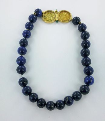 a close up of a bracelet with a gold coin on it