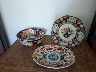 three plates and bowls sitting on a wooden table
