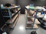 deux étagères sur lesquelles sont posées des bouteilles d'alcool, dans un garage