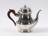 une théière ancienne en argent avec une anse en bois, sur fond blanc