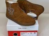 les chaussures sont posées sur la boîte, sur la surface blanche