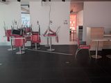 a room with a lot of red chairs and tables in it