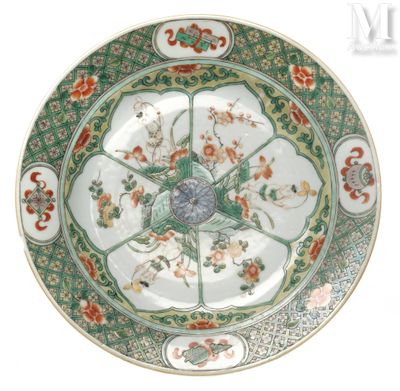 une assiette verte et blanche décorée de fleurs et d'oiseaux