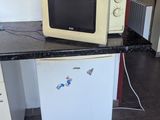two microwaves and a refrigerator in a small room