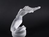 un gros plan sur une sculpture en verre représentant une main tenant quelque chose