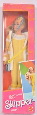 La poupée porte une tenue jaune et tient un micro.