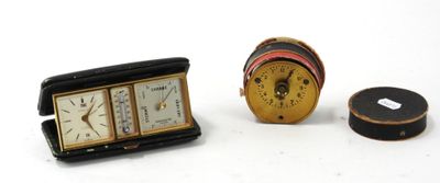 une petite horloge posée à côté d'une petite boîte