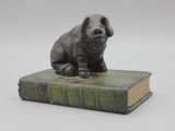 une statue représentant un chien assis sur un livre