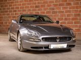 a silver sports car parked in front of a brick wall