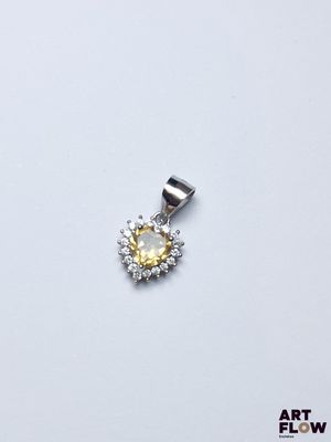 un gros plan d'un pendentif en diamants jaunes et blancs sur fond blanc