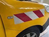 a yellow car with a red and white stripe on it