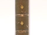 an old book that is sitting on a white surface