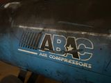 a blue air compressor sitting in a garage