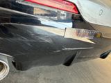 the rear end of a black car with a sticker on it ' s bumper