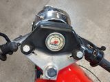a close up of a red motorcycle with a gauge on it ' s handlebars