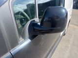 a side view mirror of a car with a reflection of a building in the window
