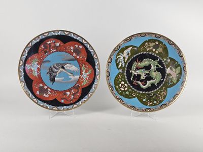 two decorative plates with birds and flowers on them on a white surface