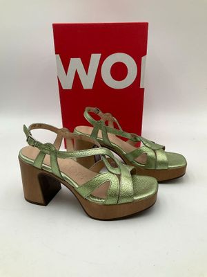 une paire de sandales vertes pour femme posées sur une surface blanche