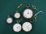 cinq types différents de montres de poche posées sur un fond vert