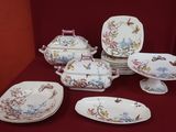 many plates and bowls on a table with a red background