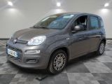 La petite voiture grise est garée sur un sol en carrelage à damier.