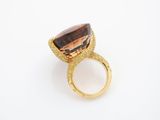 a close up of a ring with a brown stone on it