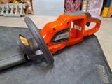 an orange chainsaw sitting on top of a table in a room