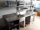 une cuisine avec un évier et un comptoir sur lequel se trouve de la vaisselle