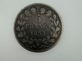 an old french 5 frans coin on a white surface