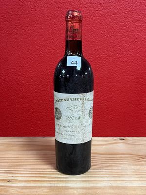 a bottle of red wine sitting on top of a wooden table