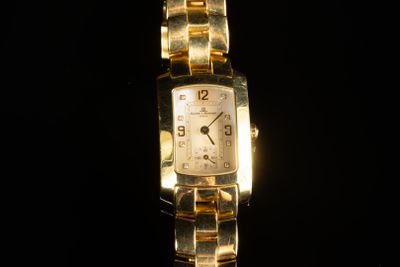 une image montrant un gros plan d'une montre en or sur fond noir