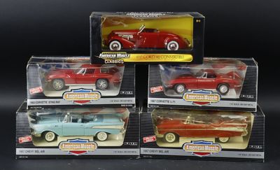 three red and blue toy cars in boxes on a black surface
