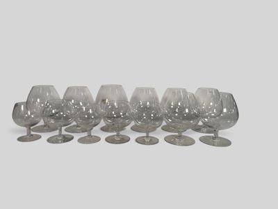 six empty wine glasses lined up on a white surface