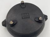 an old black pot sitting on top of a white table