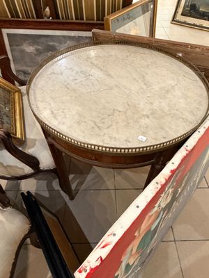 une table au plateau en marbre posée sur un sol carrelé