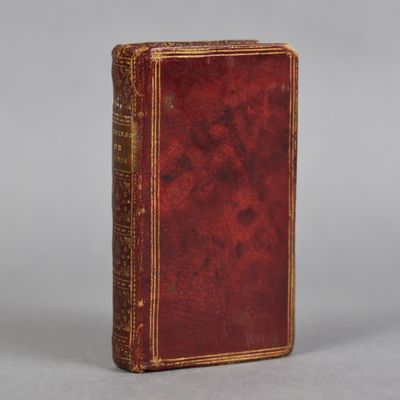 un vieux livre à la couverture rouge posé sur une table