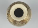 a close up of a vase on a white surface