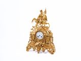 une horloge en or posée sur une surface blanche