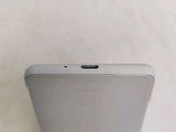 the back of a white cell phone sitting on top of a table
