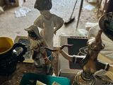 several figurines are sitting on a table in a cluttered room