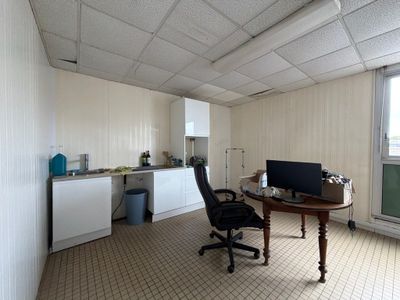 a desk with a computer and a chair in a room