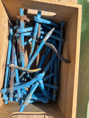 une boîte en bois remplie de clous et des clous par terre