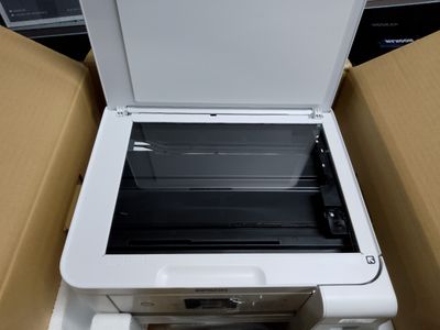 a white printer sitting inside of a box on the floor