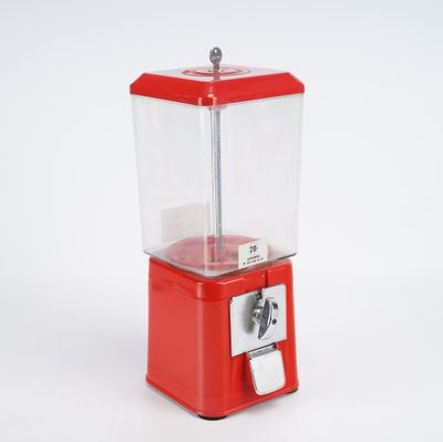 une petite machine rouge posée sur une surface blanche