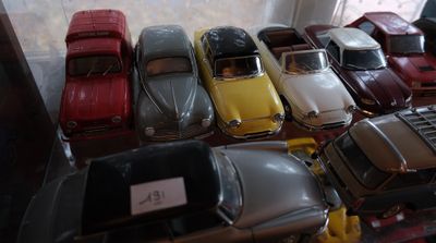 un lot de voitures-jouets exposées dans une vitrine