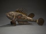 sculpture en bronze représentant un poisson à la longue queue et aux grands yeux