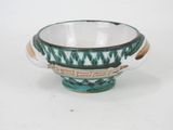 a green and white bowl sitting on a white surface